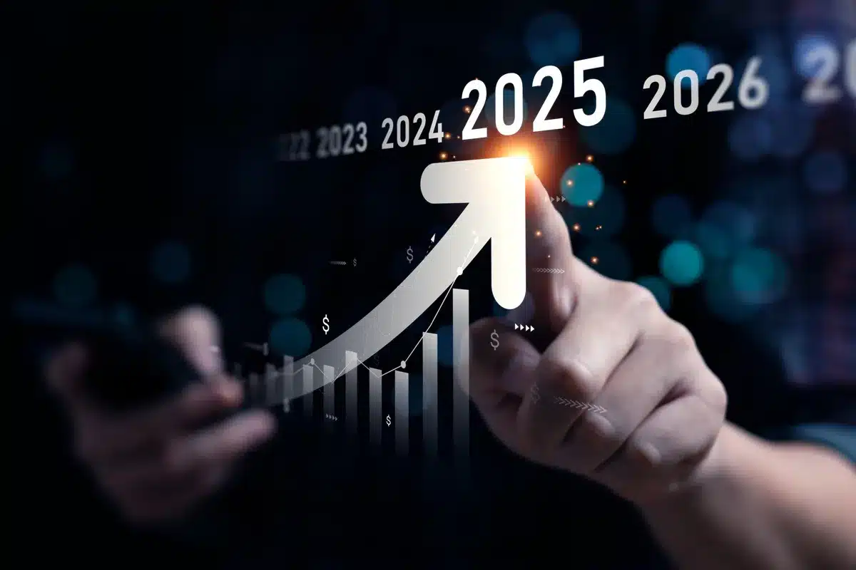 Main pointant une flèche de croissance lumineuse sur "2025". Graphique financier ascendant, symbolisant succès et objectifs futurs.